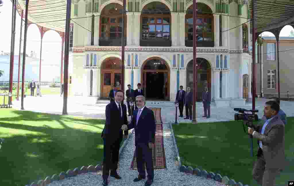 Afghanistan's chief executive Abdullah Abdullah shakes hands with Britain's Prime Minister David Cameron at the presidential palace in Kabul, Afghanistan, Oct. 3, 2014.