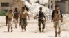 Free Syrian Army fighters walk together in the southern part of Maarat Al-Nouman, Idlib, July 16, 2014.