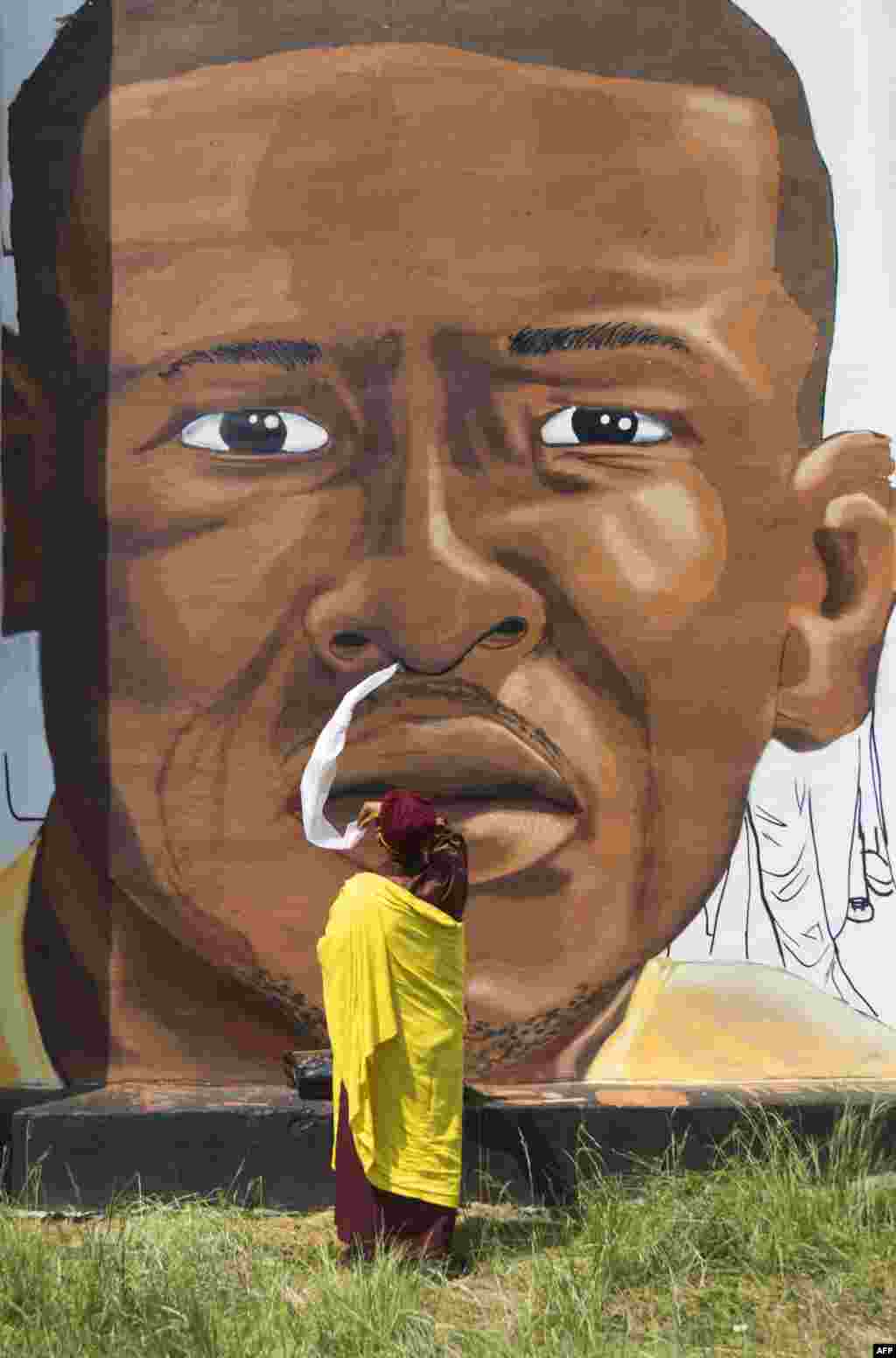 The Gyalwang Drukpa, a Buddhist leader, blesses a mural of Freddie Gray in Baltimore, Maryland.