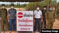 ການຕັ້ງປ້ອມຍາມກວດກາ ຫ້າມຄົນເຂົ້າໄປໃນບ້ານແຫ່ງນຶ່ງ ທີ່ຕັ້ງຢູ່ໃນນະຄອນຫລວງວຽງຈັນ ຖ້າບໍ່ຈໍາເປັນ.