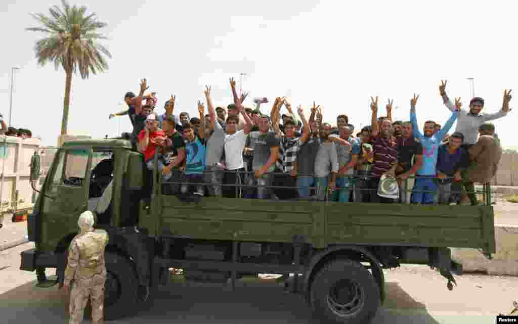 Volunteers who have joined the Iraqi Army to fight against the predominantly Sunni militants gesture from an army truck, Baghdad, June 13, 2014.&nbsp;