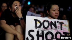 香港民眾2019年6月14日舉行集會支持6.12反對逃犯條例修法大遊行的示威者，兩名流淚的女子手持“不要開槍”的標語。