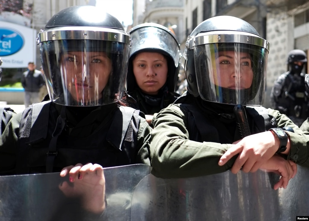 Riot policewomen stand guard next to the vice presidency building during a rally on International Women's Day, in La Paz, Bolivia.