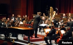 FILE - Syrian-American award-winning classical pianist and composer Malek Jandali, accompanied with an orchestra, plays the piano at the Damascus Opera House, April 1, 2010.