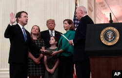 El juez retirado de la Corte Suprema de EE.UU., Anthony Kennedy, (derecha) toma la juramentación ceremonial de Brett Kavanaugh para el máximo tribunal en la Casa Blanca el lunes, 8 de octubre de 2018.