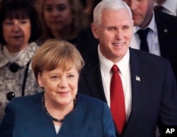 FILE - German Chancellor Angela Merkel and United States Vice President Mike Pence arrive at the Munich Security Conference in Munich, Germany, Feb. 18, 2017.