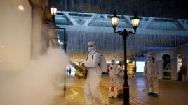 Volunteers in protective suits disinfect a shopping complex in Wuhan, Hubei province, the epicentre of China's coronavirus disease (COVID-19) outbreak, March 31, 2020. REUTERS/Aly Song