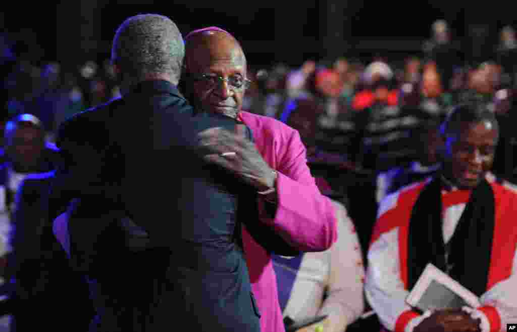Archbishop Desmond Tutu is hugged as he arrives for the funeral service for Nelson Mandela in Qunu, South Africa.