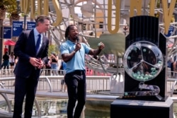 California Governor Gavin Newsom, left, looks on as Access Hollywood personality Scott Evans draws a ball with a winning number during the Vax for the Win lottery contest at Universal Studios in Universal City, Calif., Tuesday, June 15, 2021