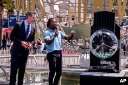 California Governor Gavin Newsom, left, looks on as Access Hollywood personality Scott Evans draws a ball with a winning number during the Vax for the Win lottery contest at Universal Studios in Universal City, Calif., Tuesday, June 15, 2021
