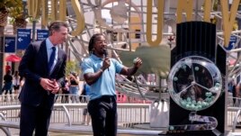 California Governor Gavin Newsom, left, looks on as Access Hollywood personality Scott Evans draws a ball with a winning number during the Vax for the Win lottery contest at Universal Studios in Universal City, Calif., Tuesday, June 15, 2021