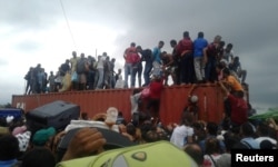 People climb atop a container used as a barricade at the Simon Bolivar international border bridge in San Antonio Del Tachira, Venezuela, April 2, 2019 in this picture obtained from social media.