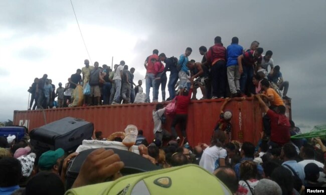 People climb atop a container used as a barricade at the Simon Bolivar international border bridge in San Antonio Del Tachira, Venezuela, April 2, 2019 in this picture obtained from social media.