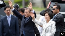 El presidente surcoreano Moon Jae-in saluda a sus vecinos y seguidores junto a su esposa Kim Jung-sook a la llegada a la Casa Azul, la residencia presidencial oficial en Seúl.