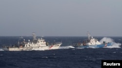 在距離越南海岸約210公里(130英里)的南中國海，越南海上警衛隊的一艘船(R)靠近一艘中國海警船。（2014年5月14日）