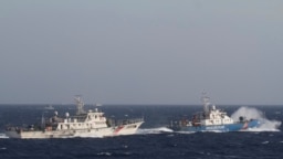 资料照：在距离越南海岸约210公里(130英里)的南中国海，越南海上警卫队的一艘船(右)靠近一艘中国海警船。 （2014年5月14日）