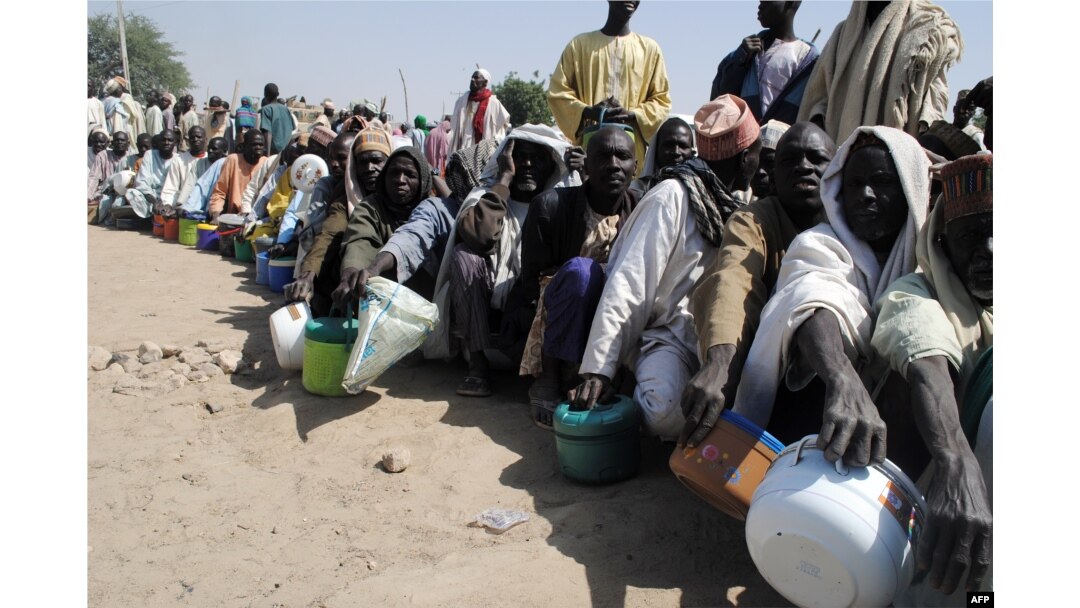FILE - Internally displaced persons wait to be served with food at Dikwa camp, in northeast Nigeria's Borno state, Feb. 2, 2016.