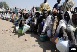 FILE - Internally displaced persons wait to be served with food at Dikwa camp, in northeast Nigeria's Borno state, Feb. 2, 2016.