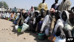 FILE - Internally displaced persons wait to be served with food at Dikwa camp, in northeast Nigeria's Borno state, Feb. 2, 2016.