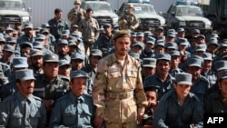 FILE - Afghan General Abdul Raziq, center, police chief of Kandahar, poses during a graduation ceremony at a police training center in Kandahar province, Afghanistan, Feb. 19, 2017.