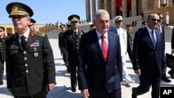 Turkish Prime Minister Binali Yildirim, center, walks with chief of general staff General Hulusi Akar at the Mausuleum of modern Turkey's founder, Mustafa Ataturk, in Ankara, July 28, 2016.