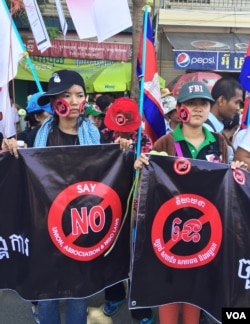 Two protesters against the controversial LANGO stand opposite the Cambodian Senate building as the bill is debated early Friday. (Robert Carmichael for VOA News)