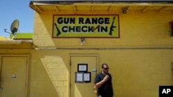 An employee smokes outside of an office for the Last Stop outdoor shooting range in White Hills, Ariz. Instructor Charles Vacca was accidentally killed at the range by a 9-year-old with an Uzi submachine gun, Aug. 27, 2014.