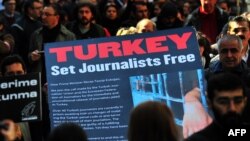 Turkish journalists carry a large sign displaying a letter to Turkish Prime Minister Recep Tayyip Erdogan that calls for the release of jailed journalists, during a demonstration on Istiklal Avenue in Istanbul, on March 13, 2011.