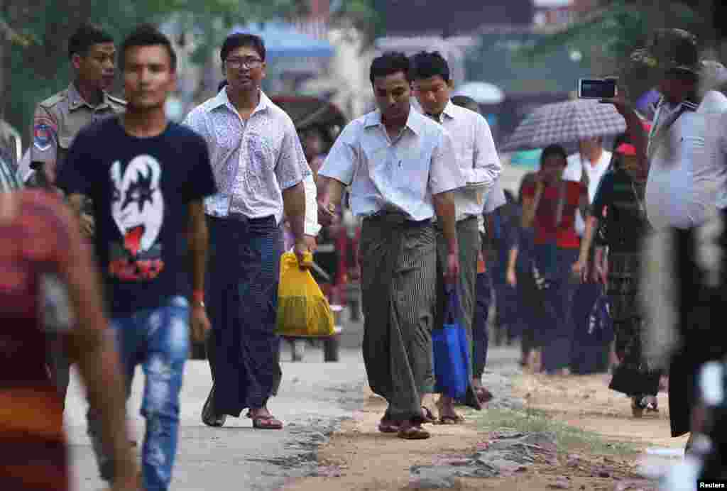 Reuters reporters Wa Lone and Kyaw Soe Oo walk to Insein prison gate after being freed, after receiving a presidential pardon in Yangon, Myanmar, May 7, 2019.