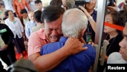 Soum Rithy (C), who lost his father and three siblings during the Khmer Rouge regime, breaks out in tears and hugs another survivor after the verdict was delivered in the trial of former Khmer Rouge head of state Khieu Samphan and former Khmer Rouge leade
