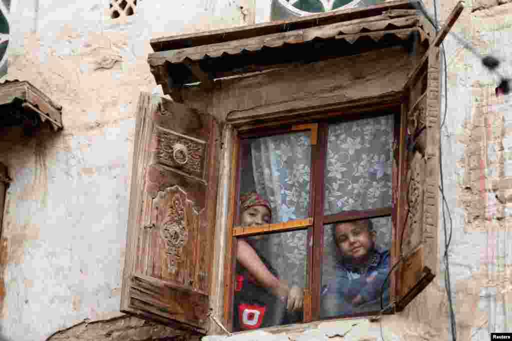 예멘 수도 사나 &#39;올드시티&#39;에 있는 주택의 창문 너머로 어린아이들이 밖을 응시하고 있다. 예멘 수도 사나의 &#39;올드시티&#39;는 2천500년 이상 주민이 거주해 온 세계적 유적지로, 유네스코는 이 지역을 이슬람 문화의 &#39;보석&#39;으로 부르고 있다.&nbsp;
