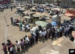 FILE - People line up as they wait to cast their vote at the Nakasero polling station in the center of Kampala, Uganda, Feb. 18, 2011.