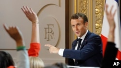 Para jurnalis mengangkat tangan dalam sesi tanya-jawab dengan Presiden Perancis Emmanuel Macron di Istana Elysee, 25 April 2019.
