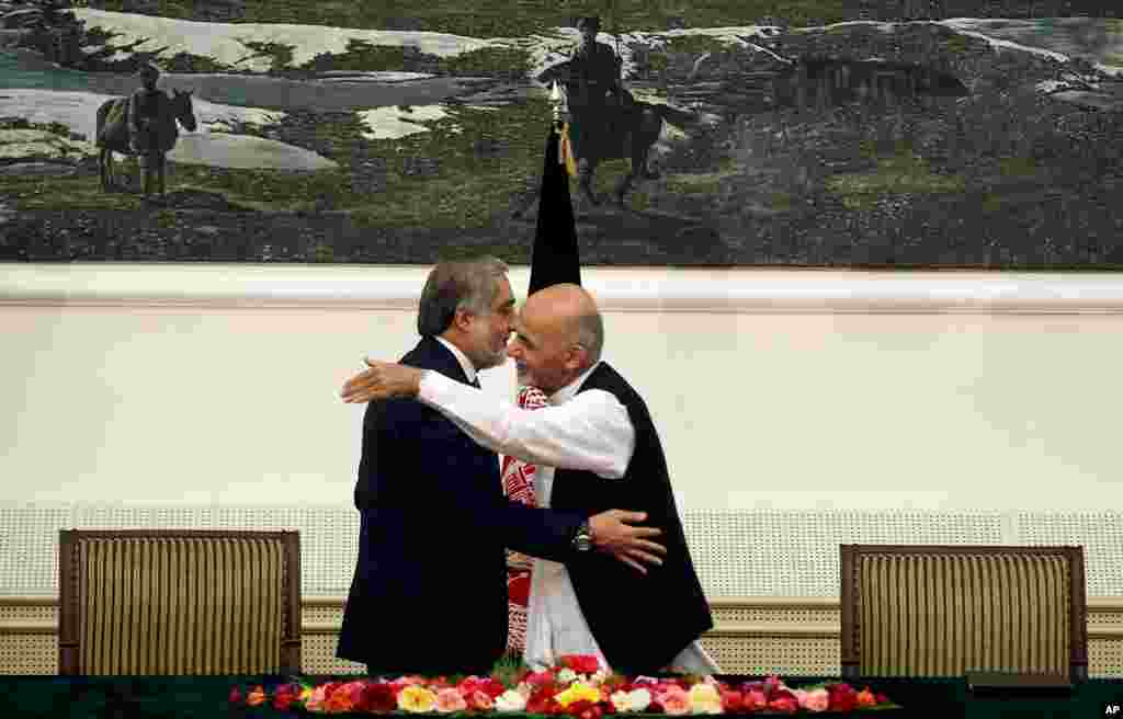Hai ứng cử viên bầu cử tổng thống Afghanistan Abdullah Abdullah, trái, và Ashraf Ghani Ahmadzai, phải, ôm nhau sau khi ký một thỏa thuận chia sẻ quyền lực tại dinh tổng thống ở Kabul. 
