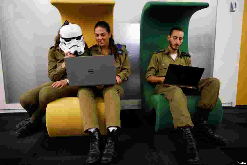 Israeli soldiers, one wearing a Star Wars Storm Trooper Voice Changing Helmet, work on laptops as they take part in a cyber security training course, called a Hackathon, at iNT Institute of Technology and Innovation, at a high-tech park in Beersheba, southern Israel.