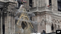 Des ouvriers installent des bâches à la cathédrale Notre-Dame de Paris, le 23 avril 2019.
