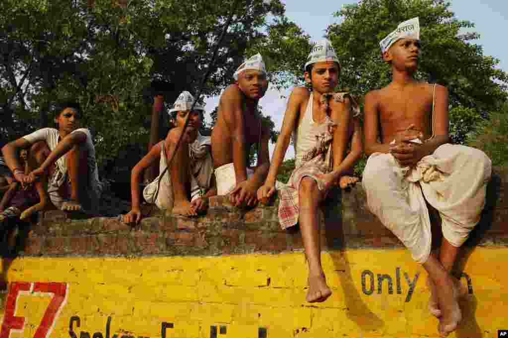 Para siswa remaja penganut Hindu memakai Aam Aadmi Party (AAP), atau Partai Rakyat, menunggu kedatangan pemimpin AAP Arvind Kejriwal dalam kampanye pemilihan di Varanasi, di negara bagian India utara, Uttar Pradesh. &nbsp;