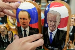 Boneka kayu tradisional Rusia bernama Matreska dari Presiden Rusia Vladimir Putin, tengah, dan Presiden AS Joe Biden, kanan tengah, di toko suvenir di Moskow, Rusia, Senin, 6 Desember 2021. (Foto: AP)