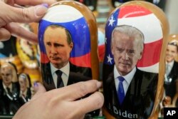 Boneka kayu tradisional Rusia bernama Matreska dari Presiden Rusia Vladimir Putin, tengah, dan Presiden AS Joe Biden, kanan tengah, di toko suvenir di Moskow, Rusia, Senin, 6 Desember 2021. (Foto: AP)
