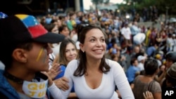 La líder opositora María Corina Machado, una ex legisladora, saluda a sus simpatizantes durante una vigilia en honor a los que han muerto durante enfrentamientos entre las fuerzas de seguridad del gobierno y los manifestantes en Caracas, Venezuela.