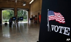 Voters cast their ballots at the Miami-Dade County Palm Springs North Fire Station, during the Florida primary election, Aug. 28, 2018, in Miami.