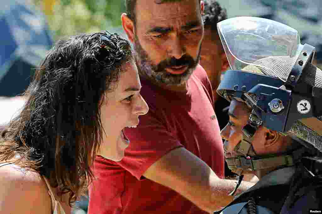 A Palestinian woman argues with an Israeli border policewoman over the Israeli demolition of a building housing an apartment and a restaurant as the building owners said they were informed by the forces that they did not obtain a construction permit, in Beit Jala in the occupied West Bank.