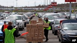 Relawan dari Greater Pittsburgh Community Food Bank, membagikan kotak makanan di tempat parkir yang dikosongkan akibat pandemi Covid-19, di Bandara Internasional Pittsburgh, Rabu, 22 April, 2020. (Foto: AP/Gene J. Puskar)