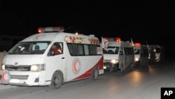 In this photo released by the Syrian official news agency SANA, ambulances of the Syrian Arab Red Crescent line up during a mission to evacuate sick and wounded people from the eastern Ghouta, near Damascus, Syria, Dec. 28, 2017.