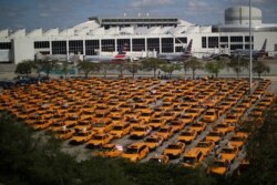 Taxis are seen at a parking lot of Miami International airport as air traffic and the tourism industry are affected by the spread of the coronavirus disease, in Miami, Florida, March 18, 2020.