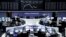 FILE - Traders are pictured at their desks in front of the DAX board at the stock exchange in Frankfurt, Germany, Aug. 21, 2015. 