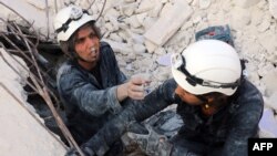 FILE - Medics search for survivors under the rubble following a reported air strike on the rebel-held neighborhood of al-Kalasa in the northern Syrian city of Aleppo, Oct. 30, 2015.