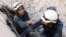 FILE - Medics search for survivors under the rubble following a reported air strike on the rebel-held neighborhood of al-Kalasa in the northern Syrian city of Aleppo, Oct. 30, 2015.