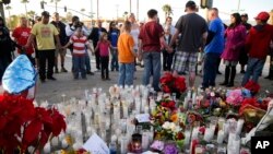 People pray at a memorial to honor the victims of Wednesday's shooting attack, Dec. 5, 2015, in San Bernardino, Calif. 