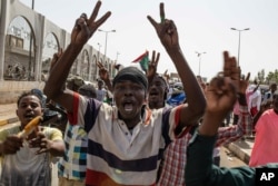 A group of protesters chant revolutionary slogans against military rule at the sit-in outside the military headquarters, in Khartoum, Sudan, Thursday, May 2, 2019.